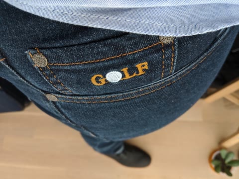 Finished jeans showing branded embroidery and pocket construction